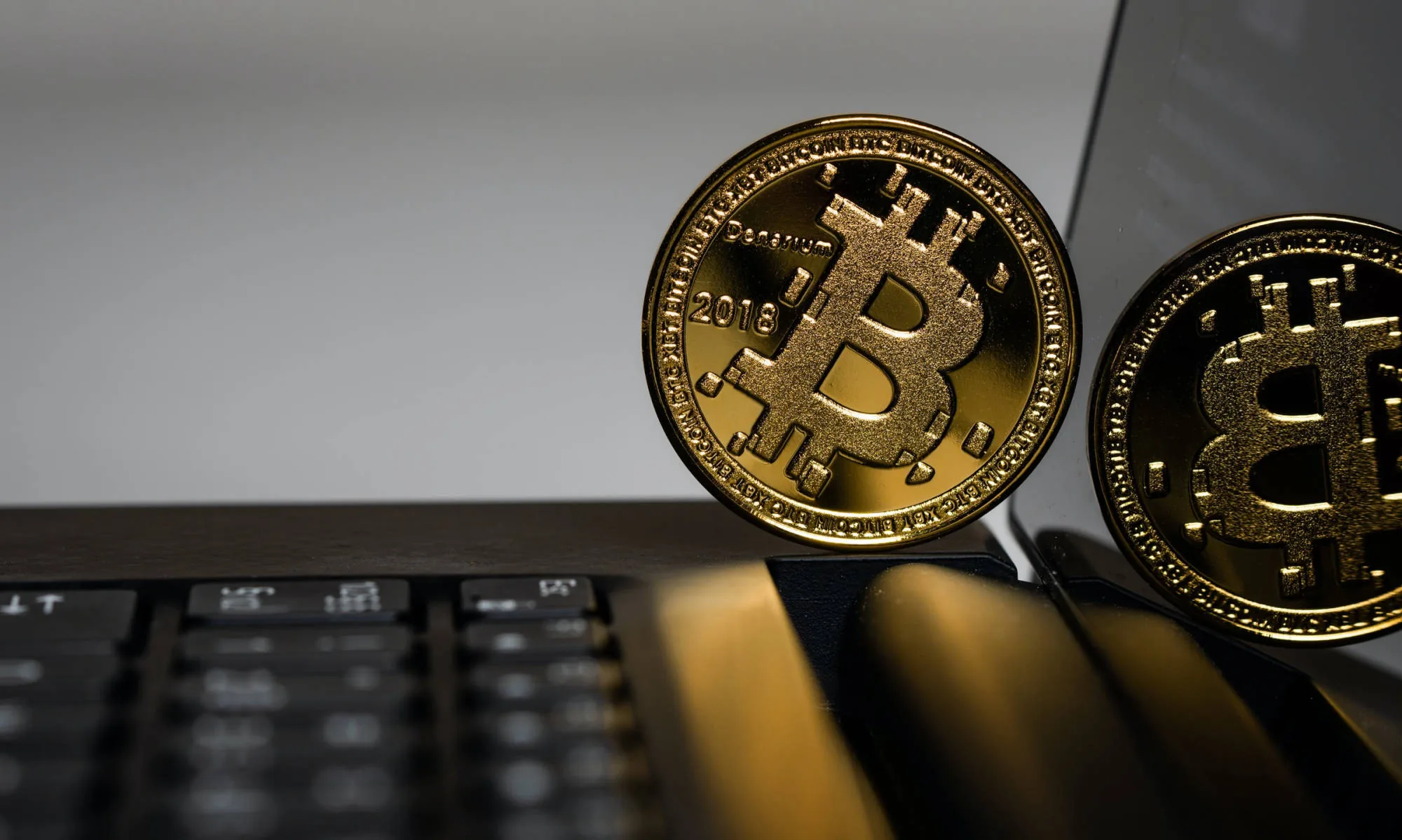 Gold Bitcoin coins on a dark desk